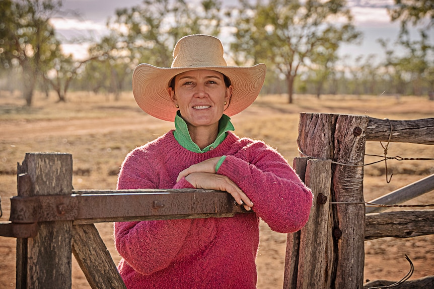 Jodie Muntelwit leans against an old wooden fence.