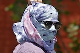 Woman covers face from sun during heatwave in India