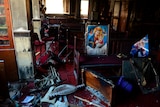 Burnt furniture, wooden tables, chairs and religious images are seen at the site of the fire