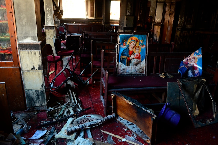 Burnt furniture, wooden tables, chairs and religious images are seen at the site of the fire
