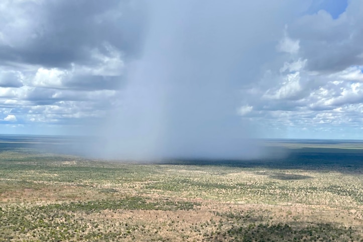 an aerial photo of an isolated storm falling on a cattle station.