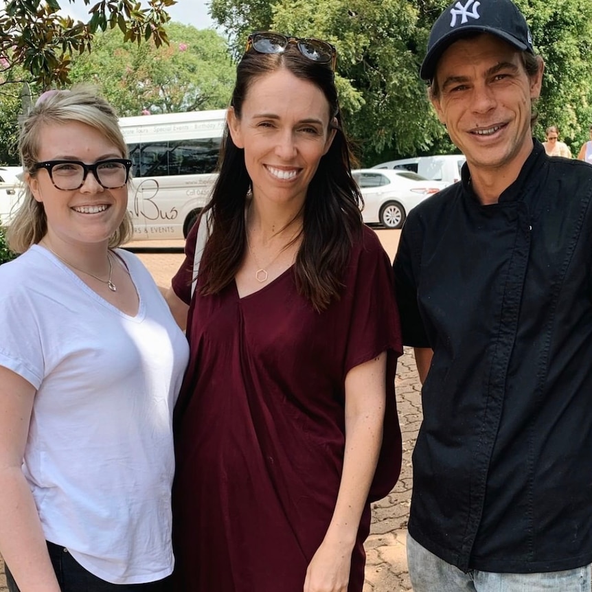 Two women and a man smile at the camera