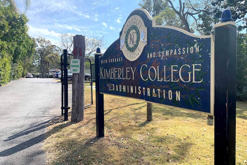 A sign marking the entrance of Kimberley College beside a road