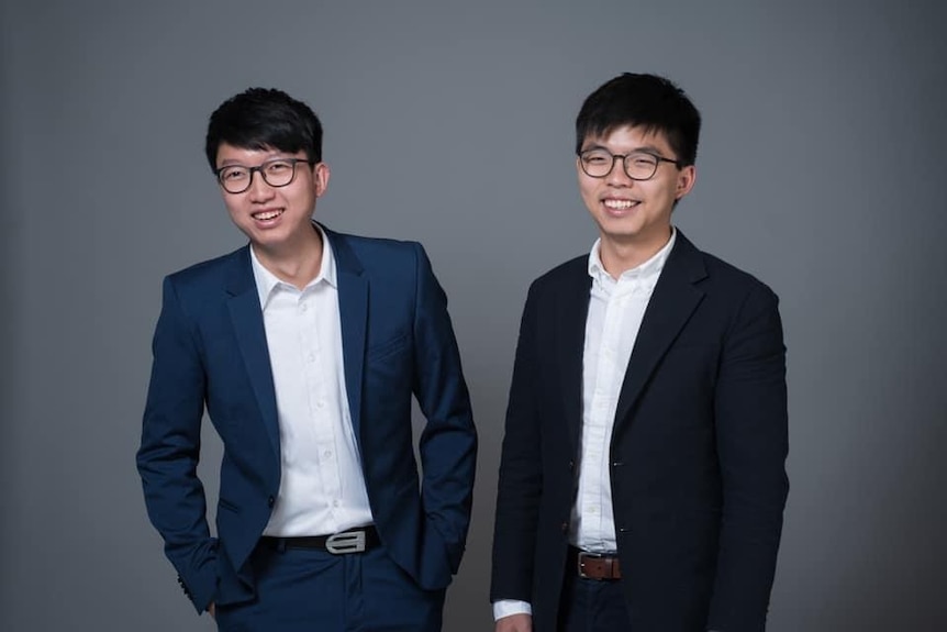 Two men from Hong Kong posing for photos in a studio