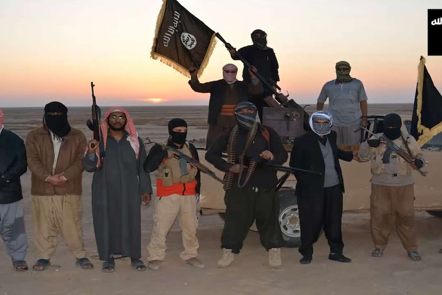ISIS militants wave a flag in Iraq
