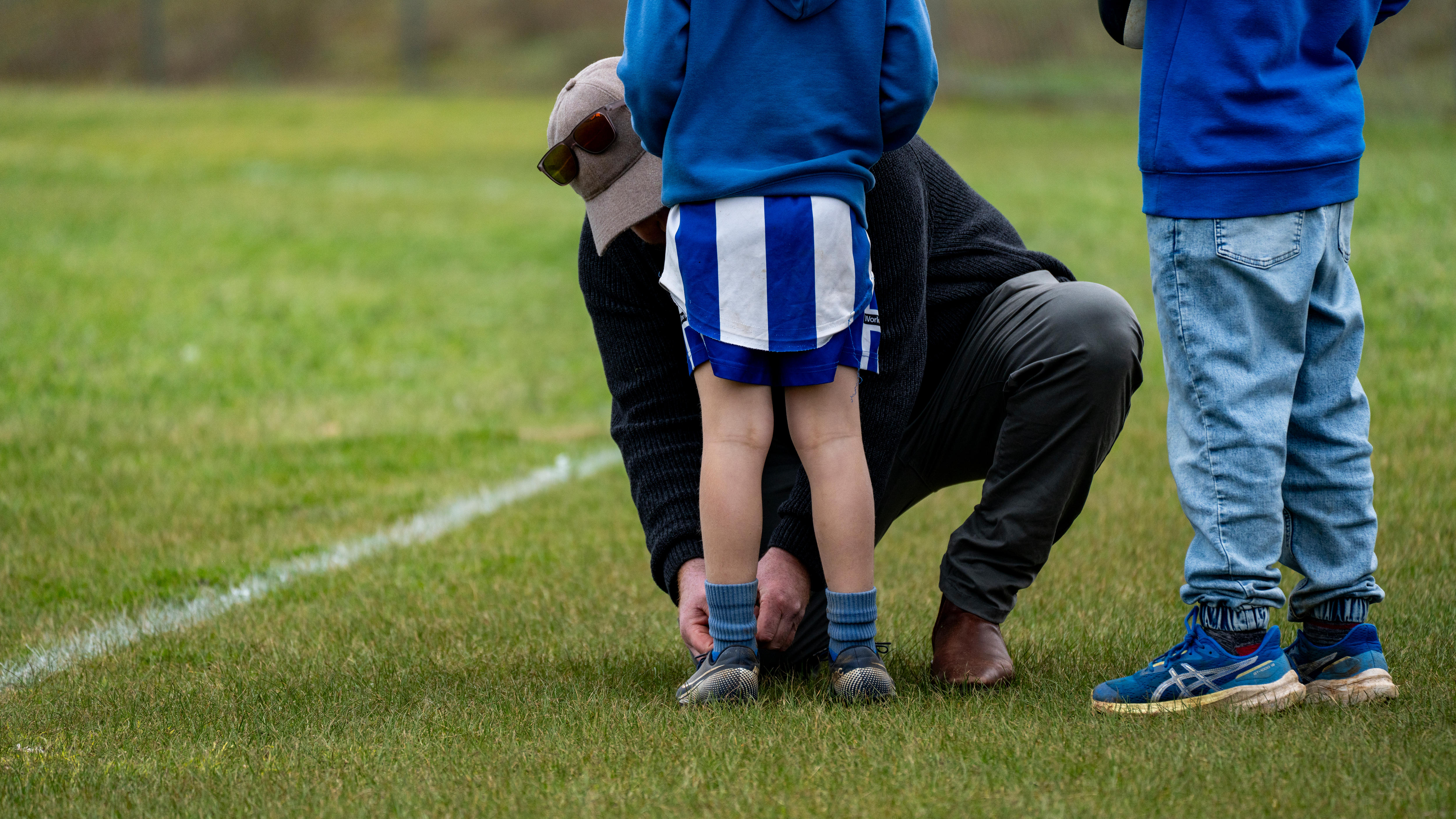 Under-14's coach Ed Ferguson ties one a boy's shoelaces.