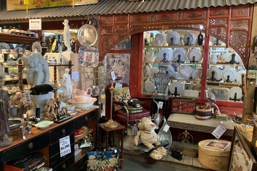 Antiques and collectables on display in shop, including statues and crockery.