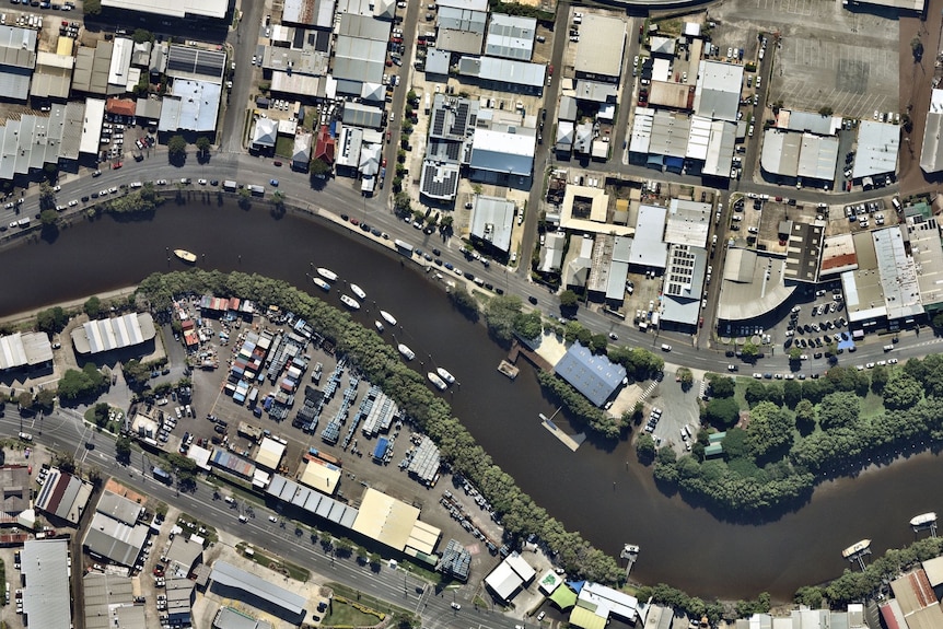 The Brisbane River at Albion, with boats and buildings along its banks, is seen from above.
