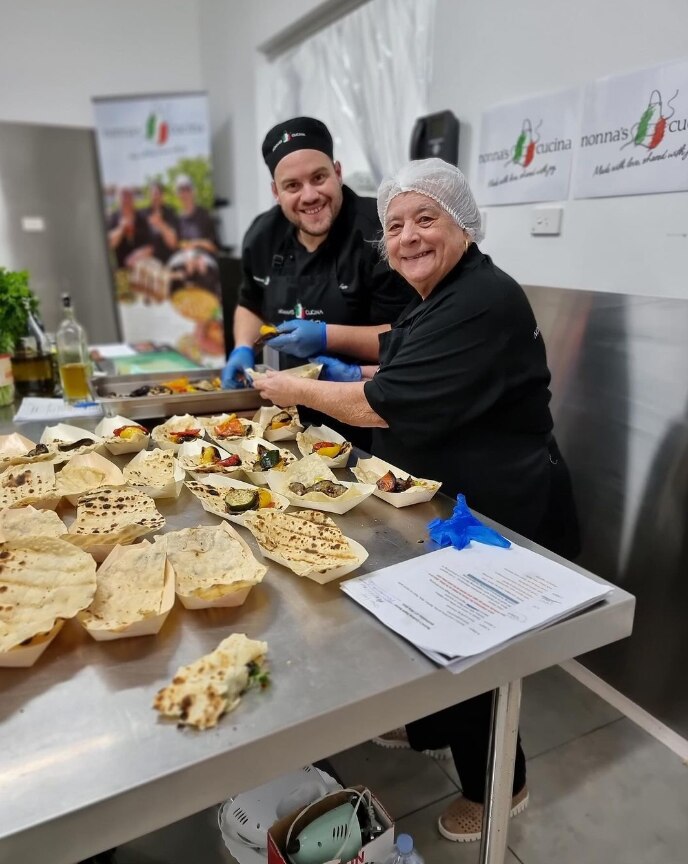 Two chefs smiling with food