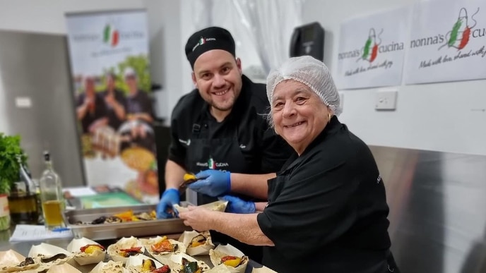 Two chefs smiling with food