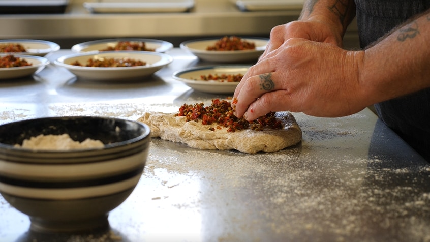 Close up of hands kneading bread.