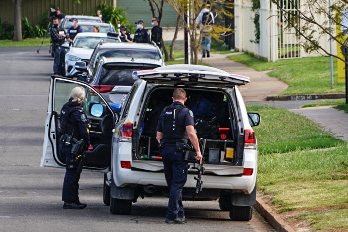 Police take guns out of the back of a four-wheel drive