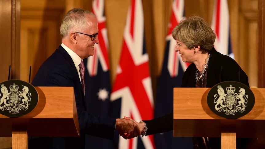 Malcolm Turnbull and Theresa May smile and shake hands during a news conference at Downing Street.