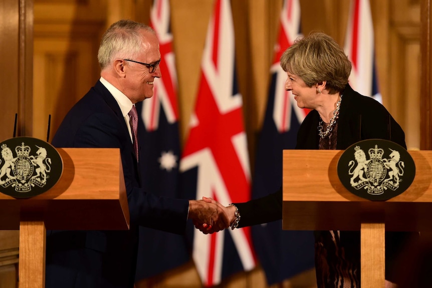 Malcolm Turnbull and Theresa May smile and shake hands during a news conference at Downing Street.