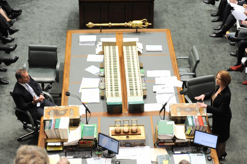 Tony Abbott listens to Julia Gillard during Question Time. (AAP: Alan Porritt)