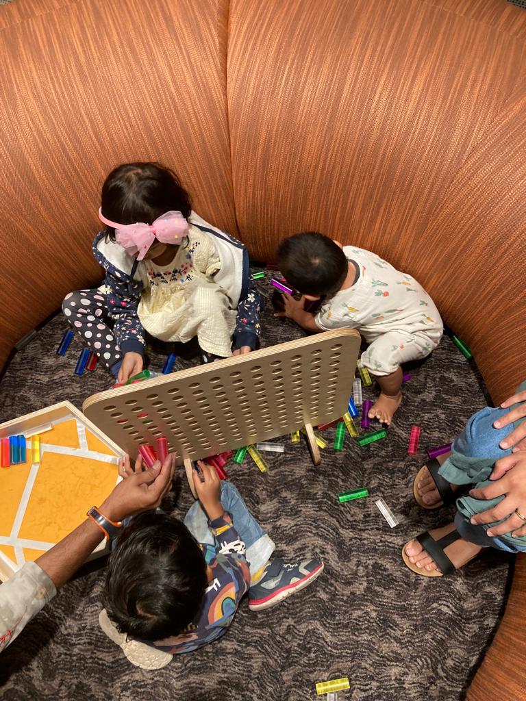 A photo of Raidah's children playing with toys, shot from an above angle so faces are not showing.