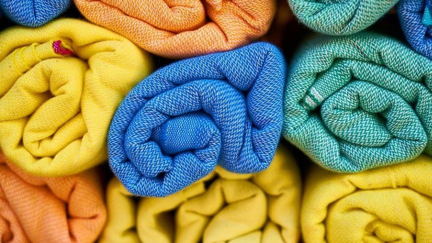 Photo of rolled up fabric, the fabric is blue and yellow and orgage 