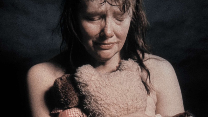 Photo of nude woman holding teddy bear