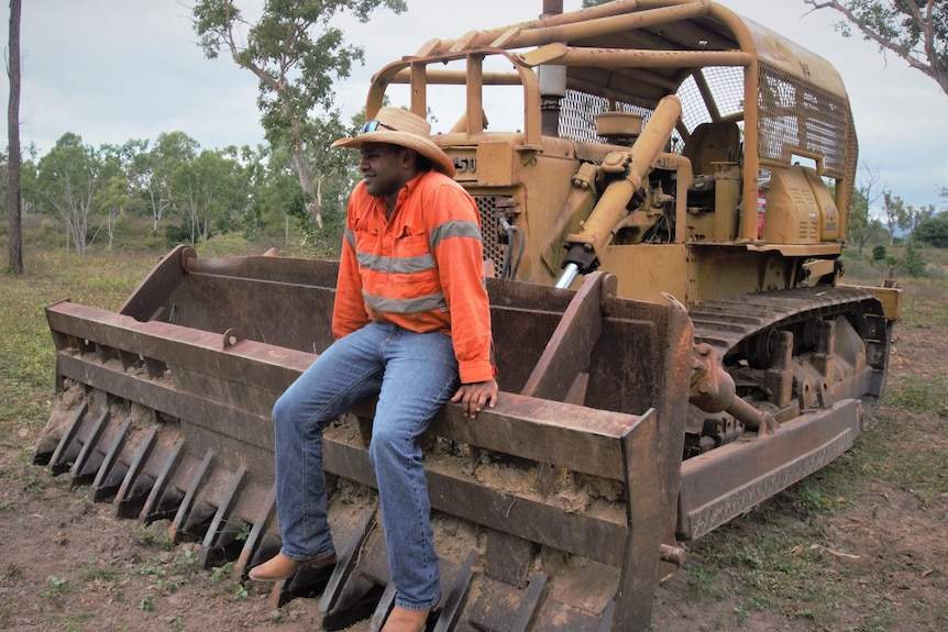 man sitting on a bulldozer on a farm