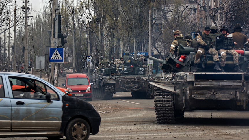 Russian tanks roll along a street in an area controlled by Russian-backed separatist forces in Mariupol.