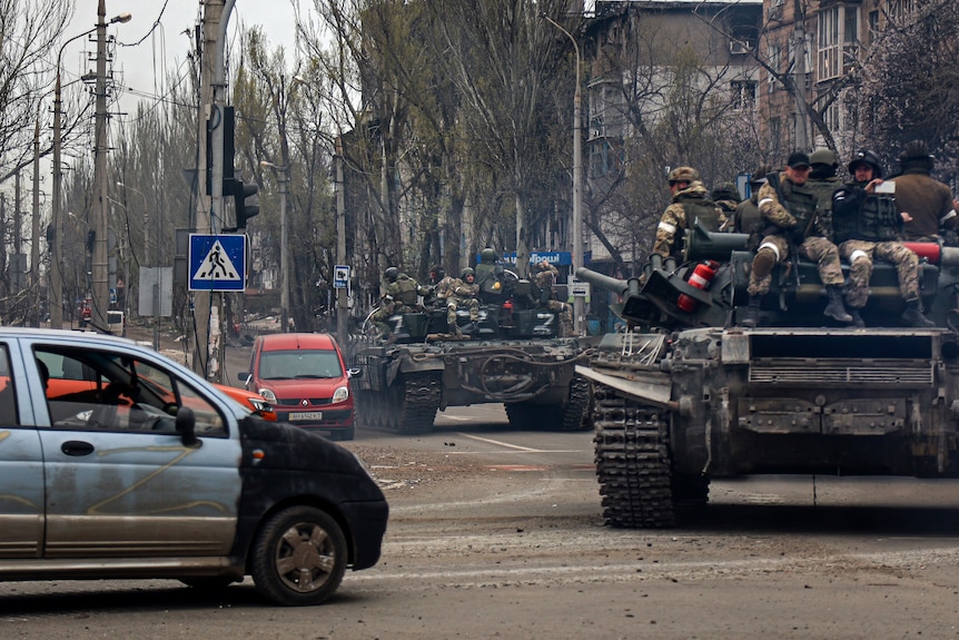 Russian tanks roll along a street in an area controlled by Russian-backed separatist forces in Mariupol.