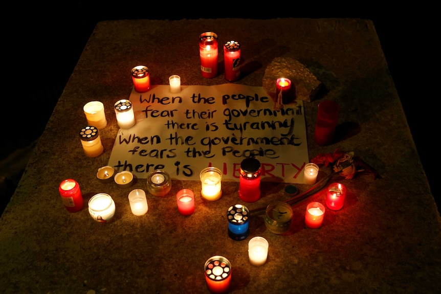 A message surrounded by candles reads "When the people fear their government there is tyranny"
