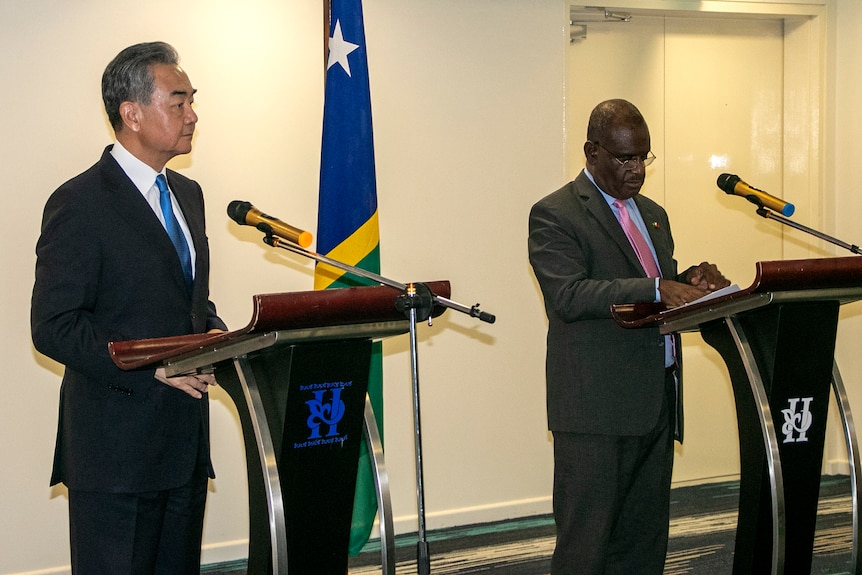 Two men stand behind lecterns.