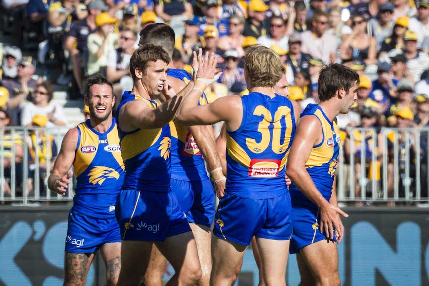 West Coast Eagles players celebrate a goal against Port Adelaide Power.