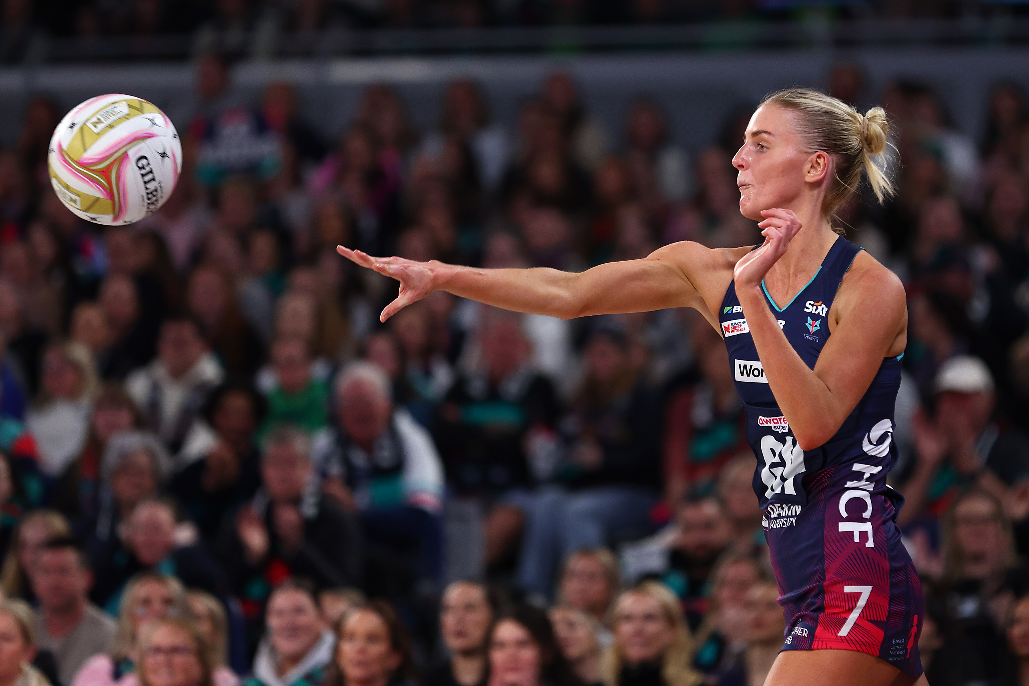 A player's right arm is outstretched as they let the ball go