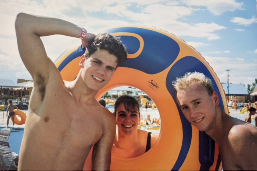 Three young adults in front of the pool. 