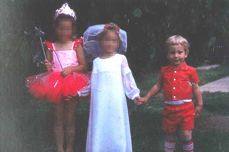 Two girls and a boy play dress ups. The girls' faces are pixelated.