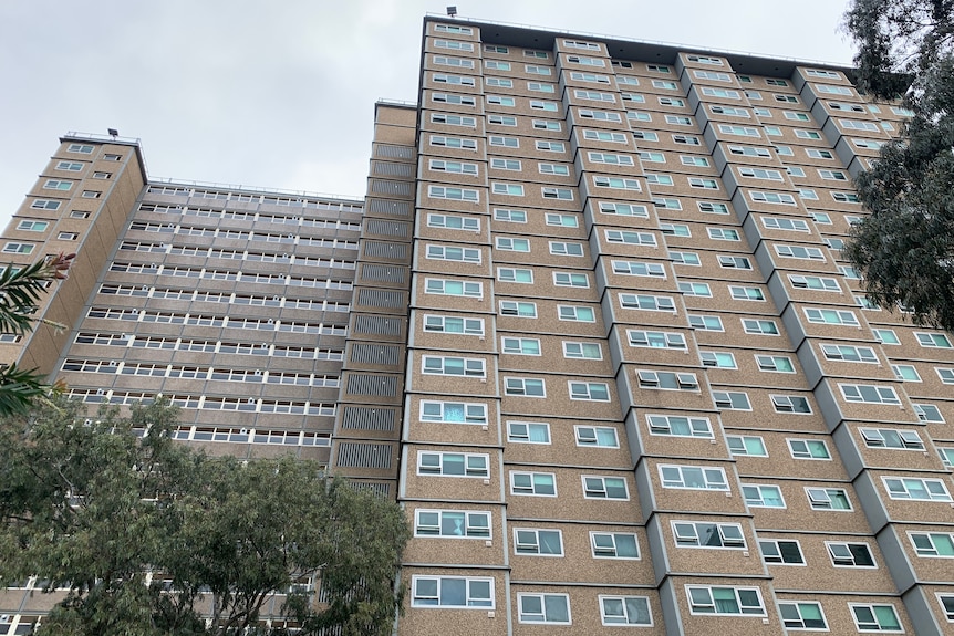 A low angle photograph of a tall apartment tower.