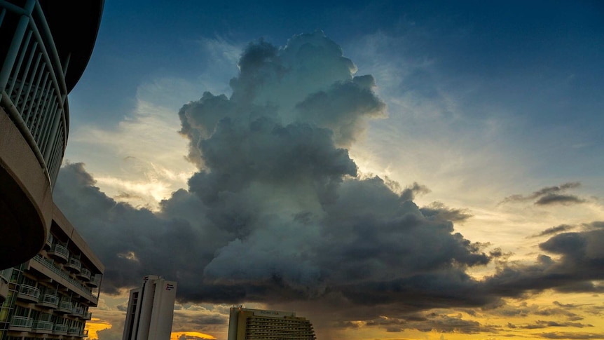 View from high rise apartment of huge storm clouds at sunset over Guam beachfront.