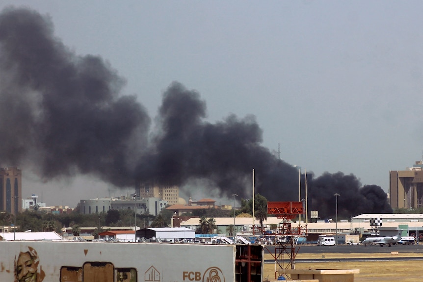 Heavy smoke bellows above buildings in the vicinity of the Khartoum airport 