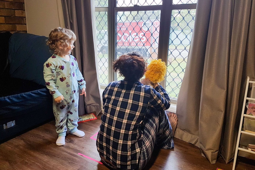 Kristin and her daughter Sophia look out the window as a delivery truck arrives.