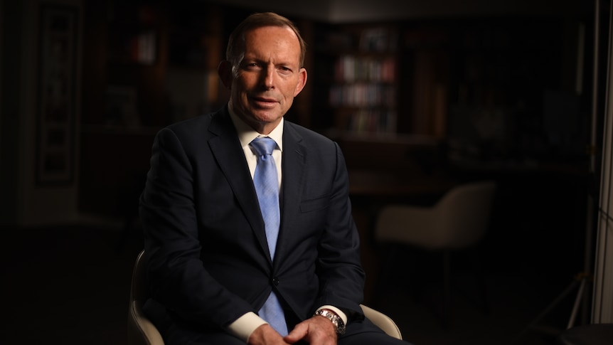 Tony Abbott sits in a chair with his hands in his lap.