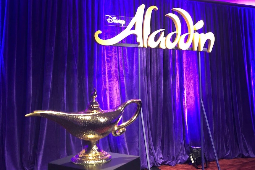 Genie's lamp placed in front of an Aladdin backdrop.
