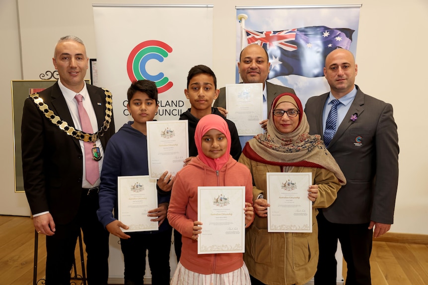 Family posing with their Australian citizenship certificates 