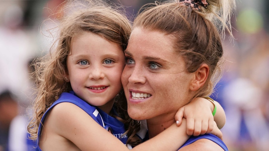 Sophie Abbatangelo holds a small child, who is holding her around her neck