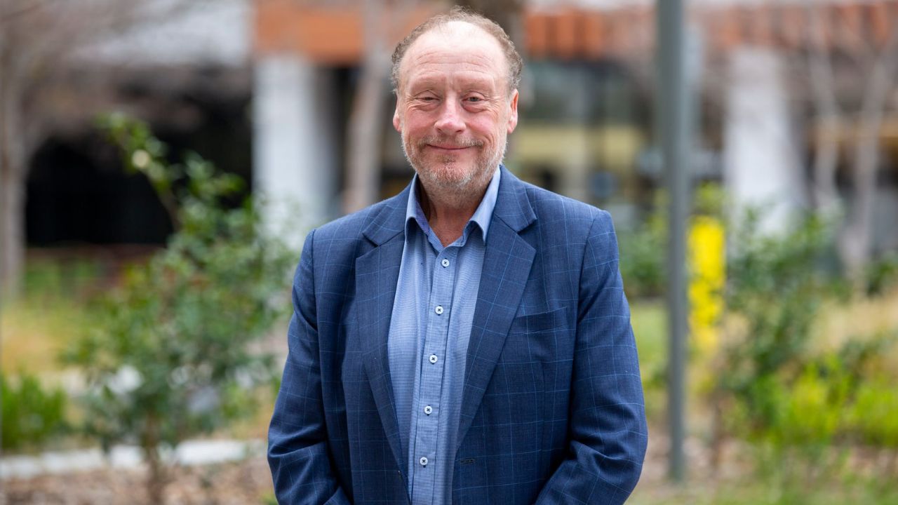 Un hombre con traje azul mira la cámara.