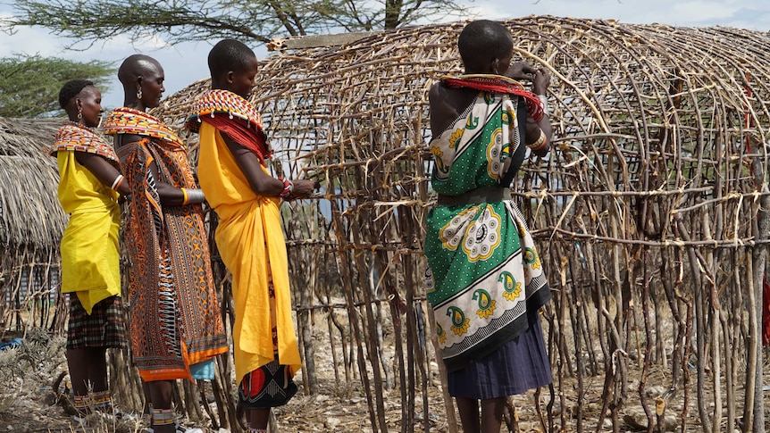 Some of Unity village women building a hut within the village