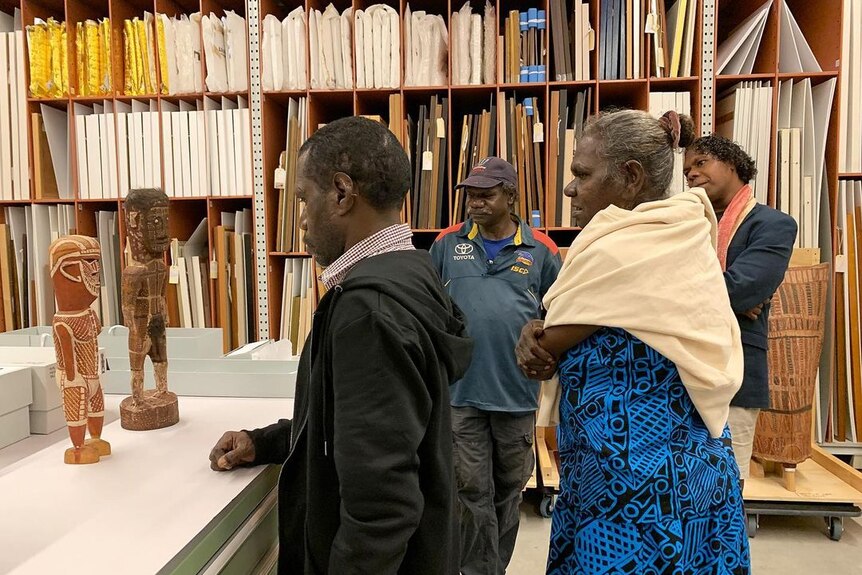Pedro Wonaeamirri (left) inspecting the Art Gallery of NSW's historical Tiwi collection in 2023.
