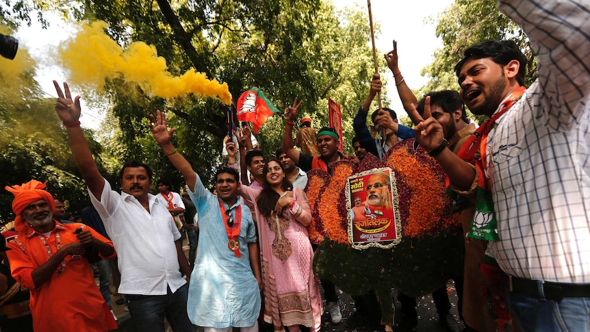 Celebrating supporters of India's Bharatiya Janata Party with a portrait of Hindu nationalist leader Narendra Modi.