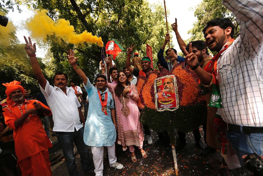 Celebrating supporters of India's Bharatiya Janata Party with a portrait of Hindu nationalist leader Narendra Modi.