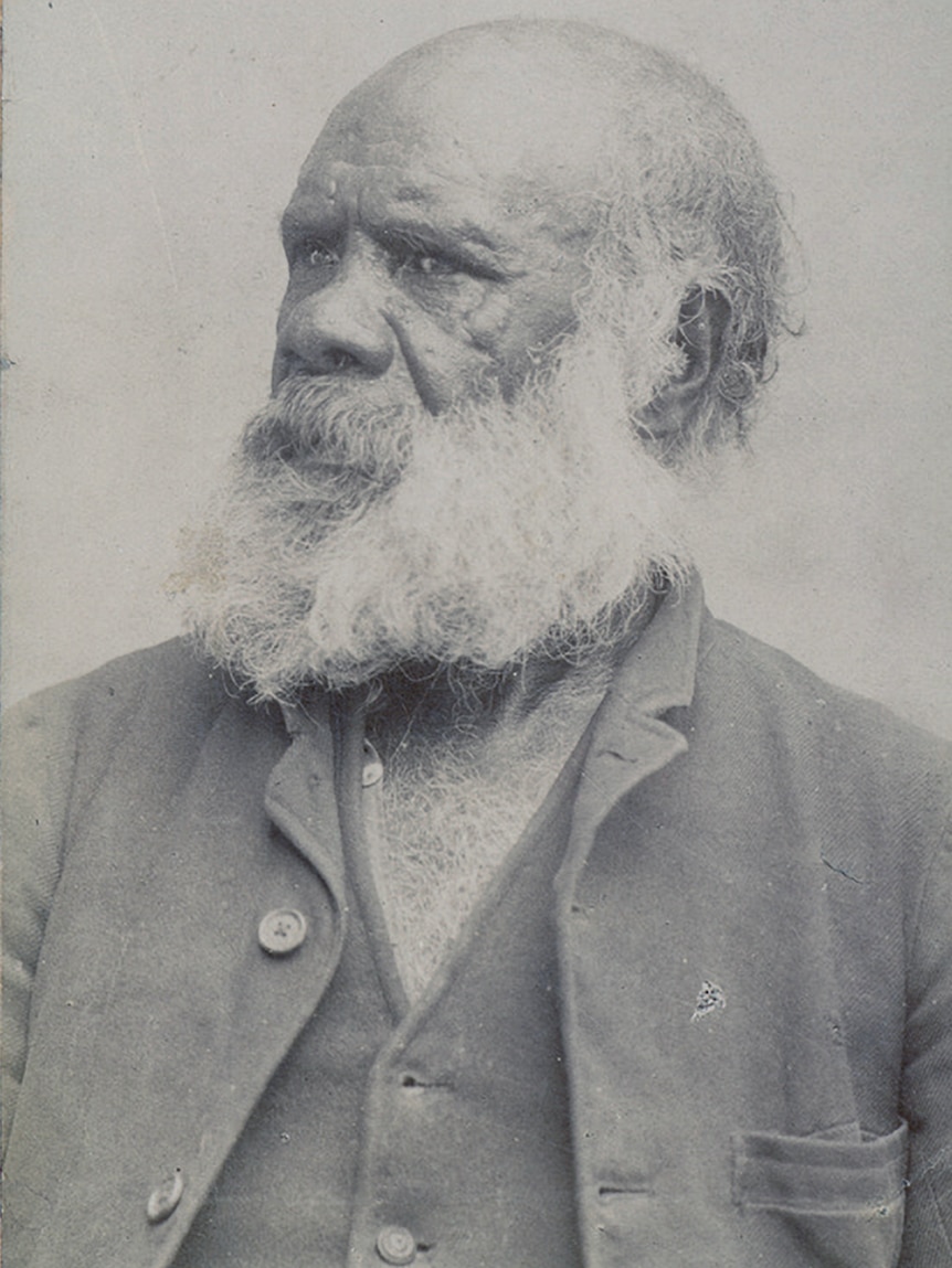 Black and white photo of an Indigenous man with a bushy beard.