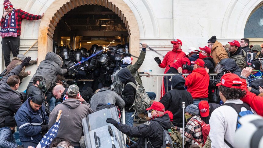 Rioters clash with police trying to enter the Capitol building.