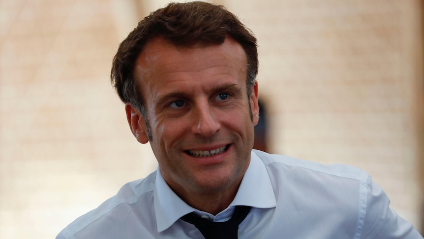 Emmanuel Macron looks to the left. 