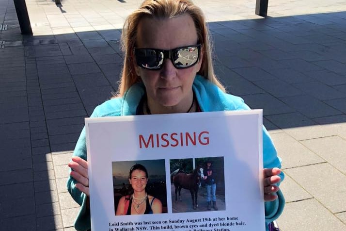 A woman in a wheelchair holding a sign.