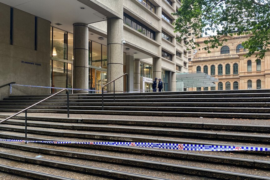 Police crime scene tape stretches across a set of stone steps outside St Andrew's Cathedral School in Sydney CBD
