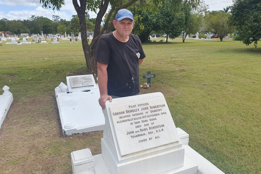 Man standing in front of grave